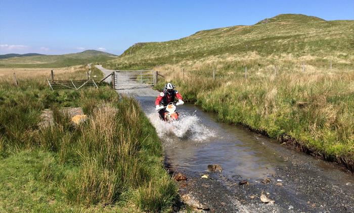 Motorcyclist fording a stream